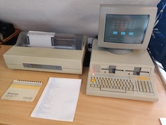 Another image of the Olivetti M20, next to the printer, showing a space invaders-like game.